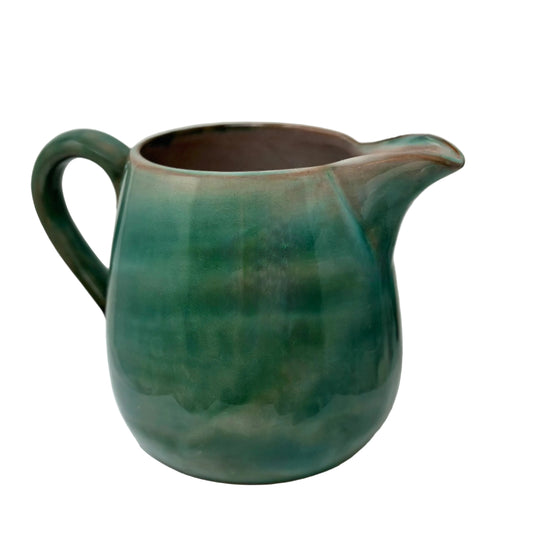 Green ceramic pitcher on a white background