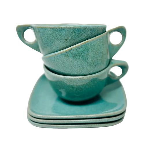 Set of three turquoise ceramic cups and saucers on a white background